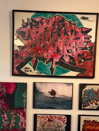 Wall-mounted collection of graffiti-inspired paintings, ocean scenes, and abstract forms Wall-mounted collection of graffiti-inspired paintings, ocean scenes, and abstract forms